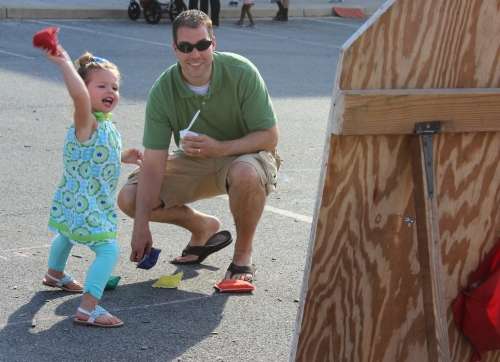 Little girl playing bean bag toss