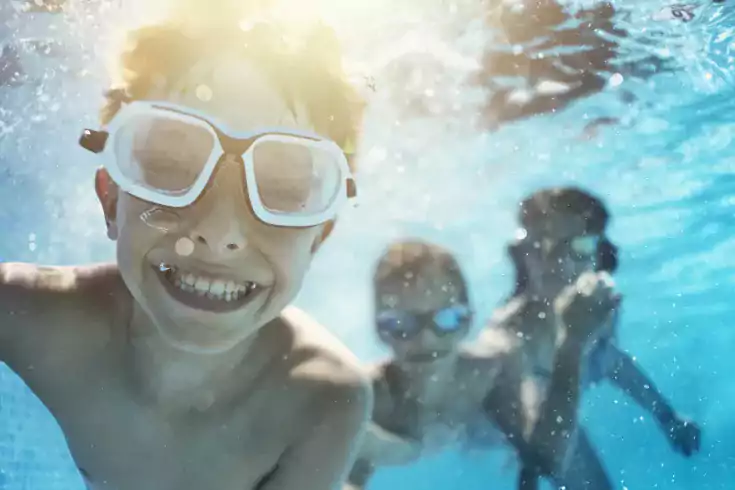 Kids swimming underwater and smilling