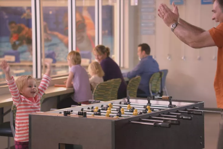 Dad and daughter playing foosball