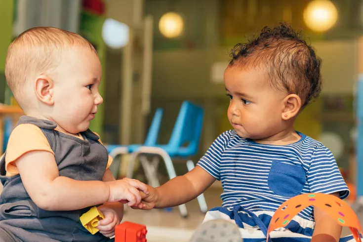 Two babies engaging with each other
