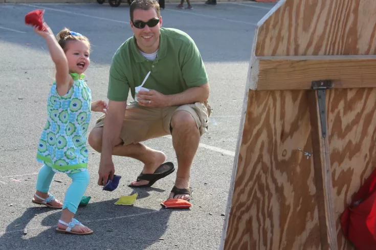 Little girl playing bean bag toss