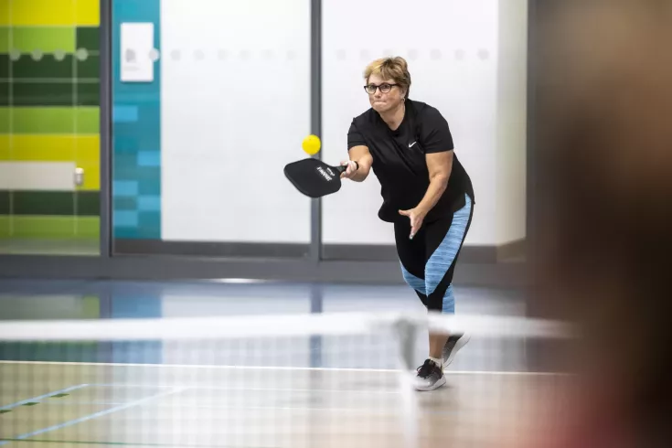 Woman serving in pickleball game
