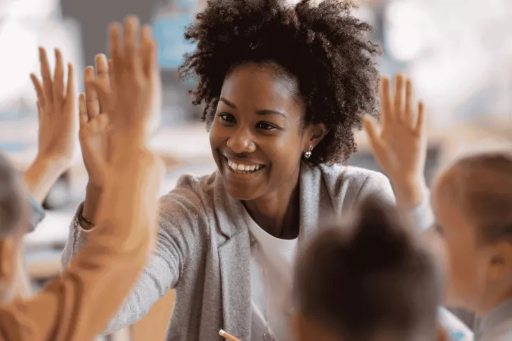 Teacher giving students a high-five