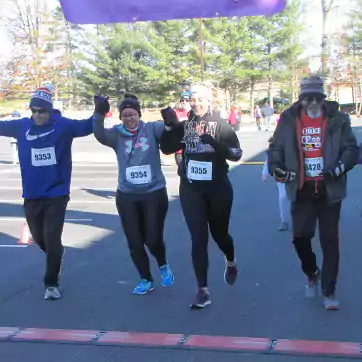 Runners crossing finish line with hands raised