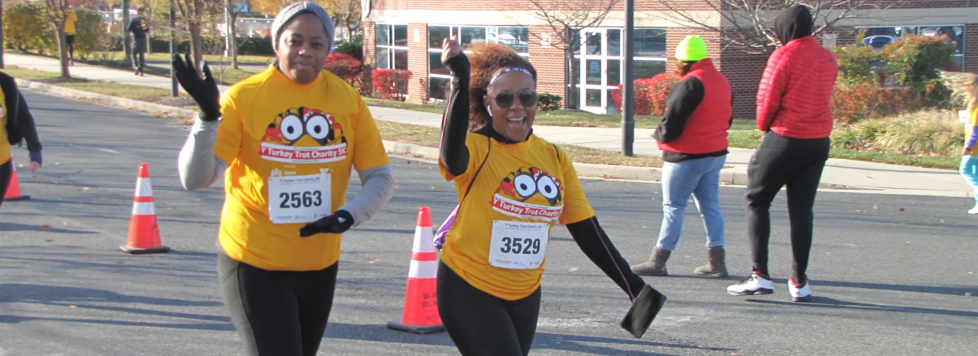 Two ladies waving during turkey trot 5k