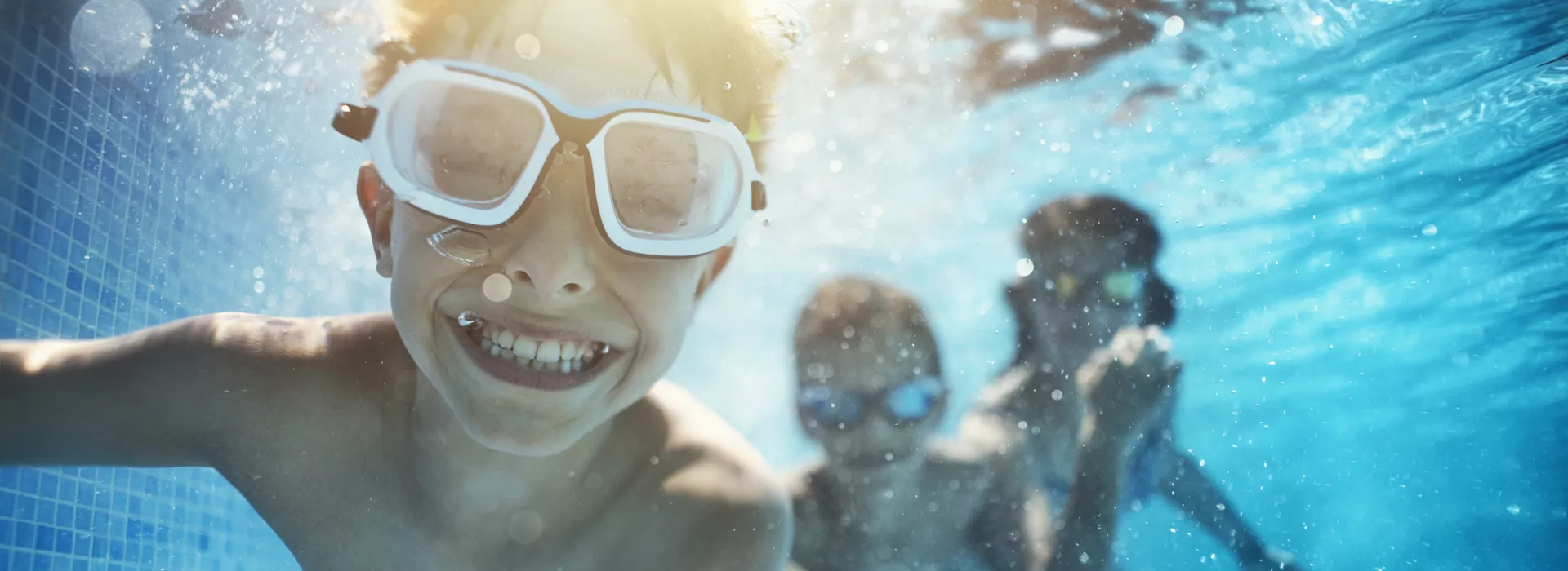 Kids swimming underwater and smilling
