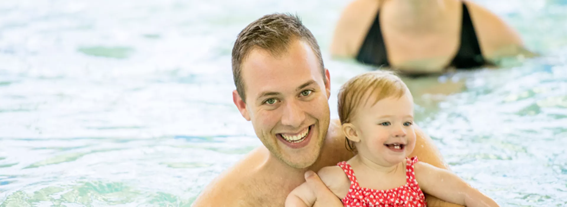 Dad and daughter playing in the pool