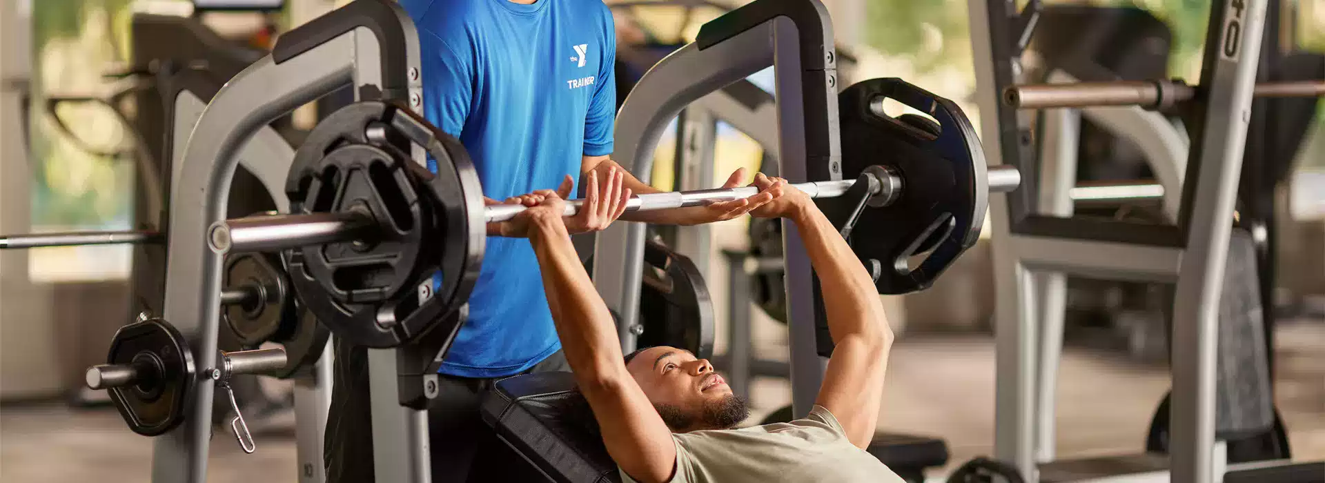 Man lifting weights with a spotter