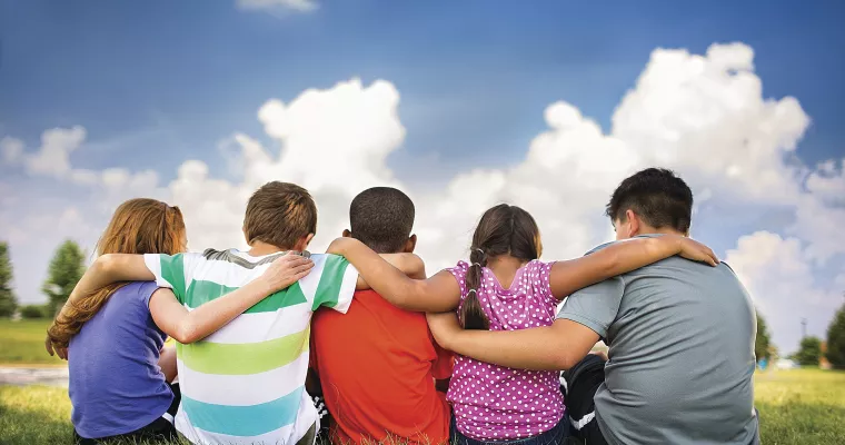 5 friends with arms around each other