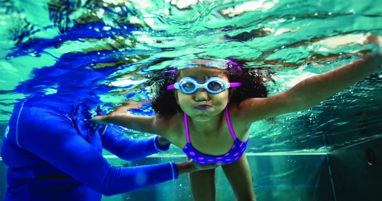 Little girl underwater during a swim lesson