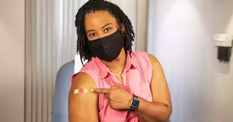 Women smiling behind mask after getting her covid vaccine