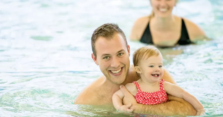 Dad and daughter playing in the pool